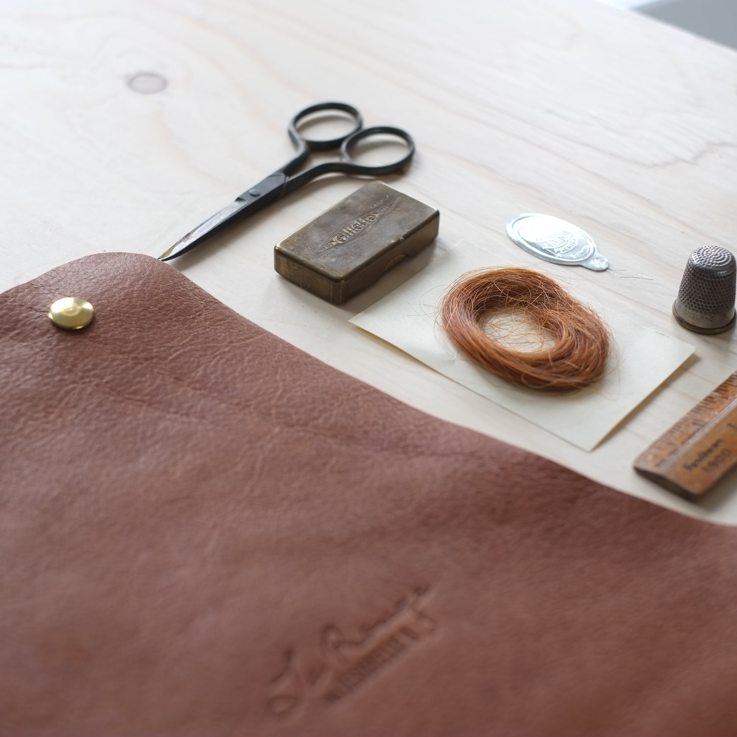 Close up of a brown leather bag with red hair from my grandmother who was called La Rouge because of it / Gros plan d'un sac de cuir La Rouge avec les cheveux authentiques de ma grand-mère qui portait ce surnom