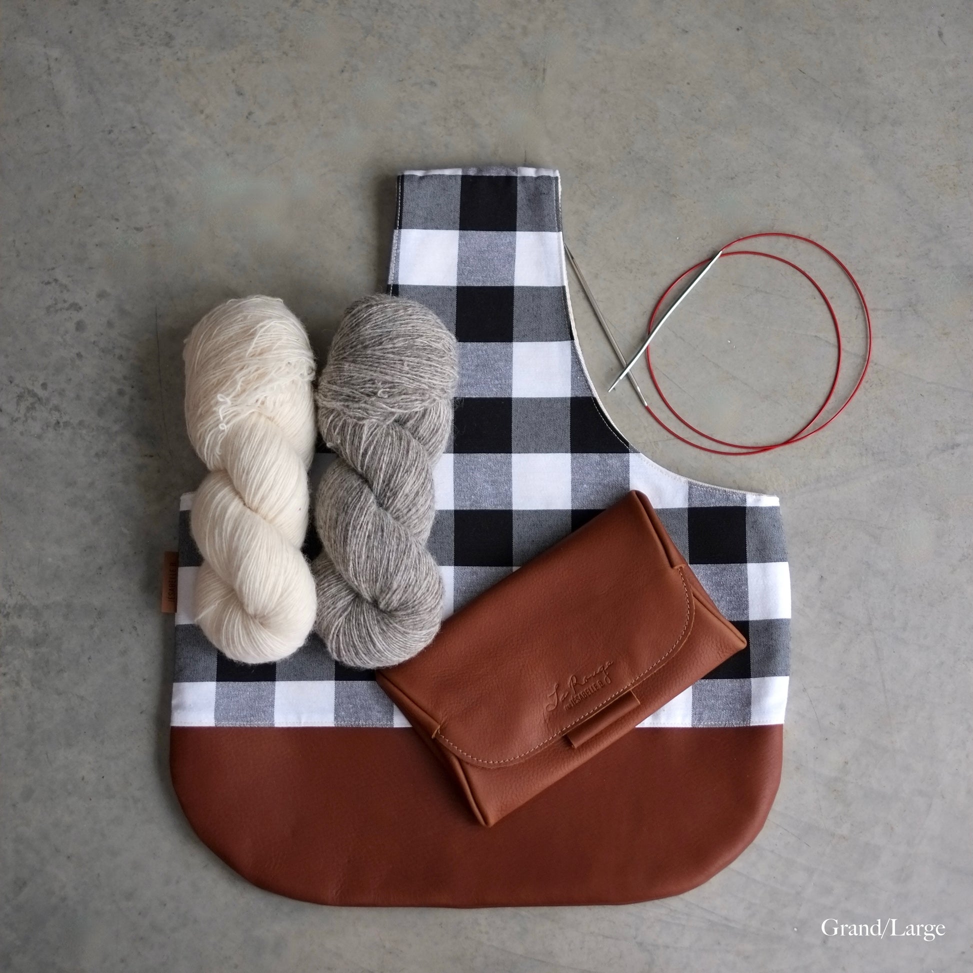 Top view of a large project bag for knitting in black and white buffalo plaid with a brown leather bottom