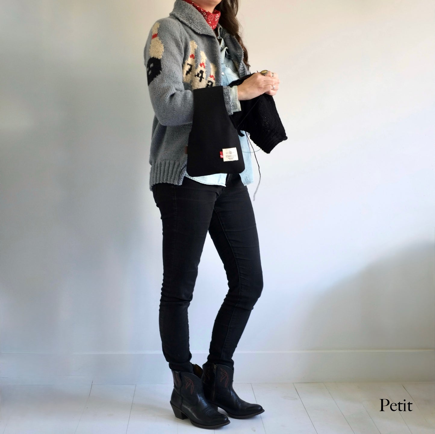 Femme qui tricote avec un petit sac à projet en canvas noir au poignet — Woman knitting with small black canvas wrist project bag