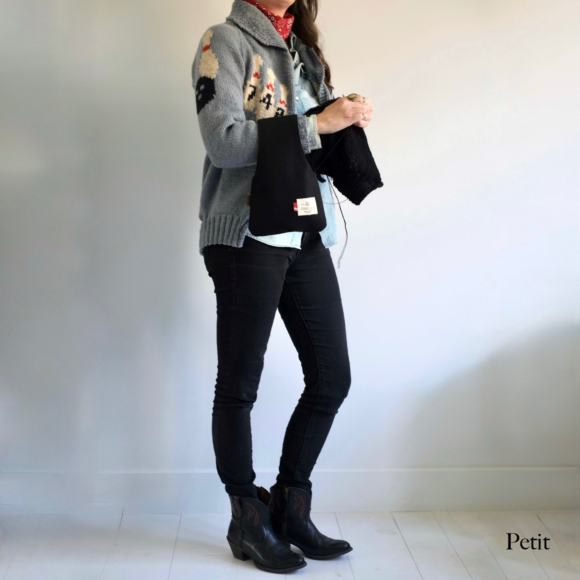 Femme qui tricote avec un petit sac à projet en canvas noir au poignet — Woman knitting with small black canvas wrist project bag