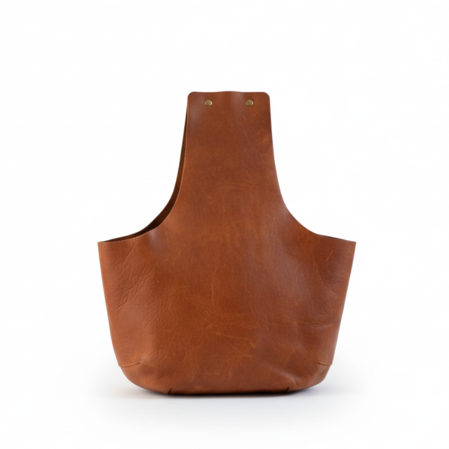 Product view of a simple clean lined leather knitting bag in all it's glory / Vue de produit du sac de tricot en cuir brun avec les bouton pression sur le dessus