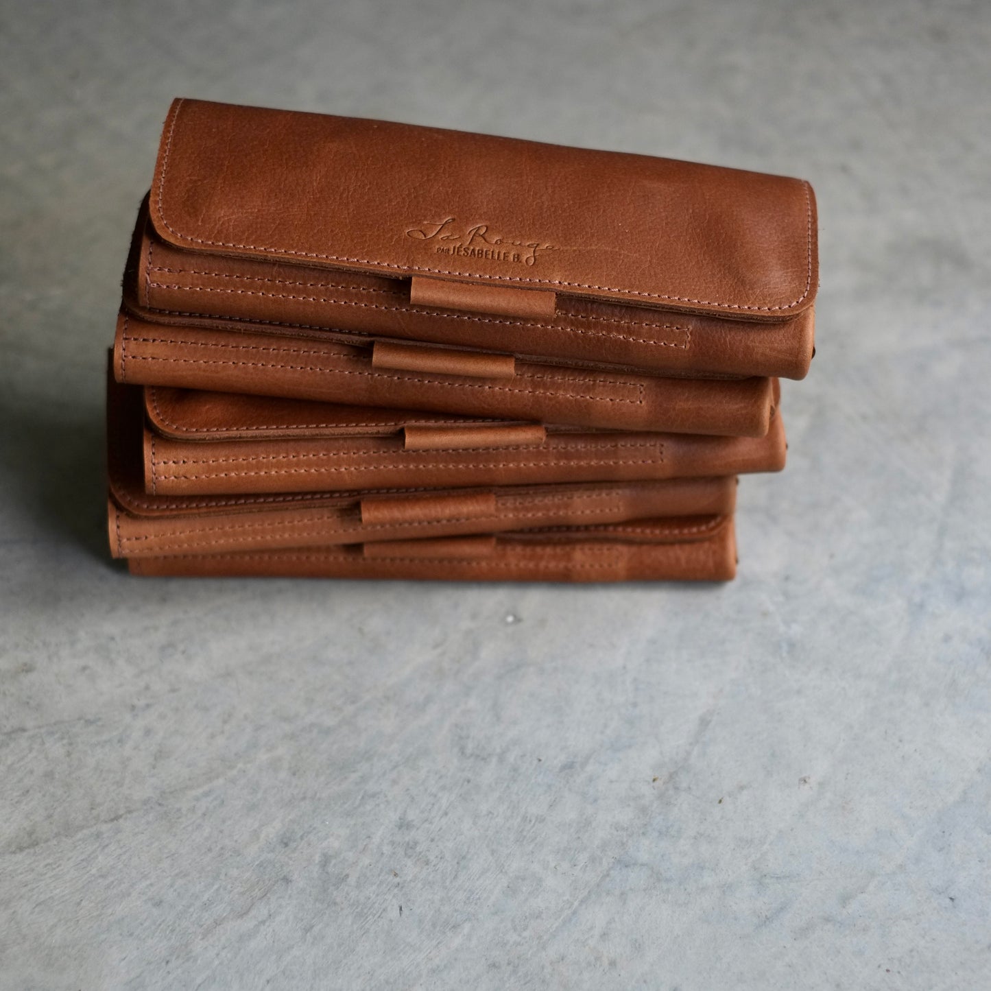 Brown leather needle cases stacked — compact and lightweight for knitters on the go / Étuis en cuir brun empilés — format compact et léger pour tricoteuses en déplacement