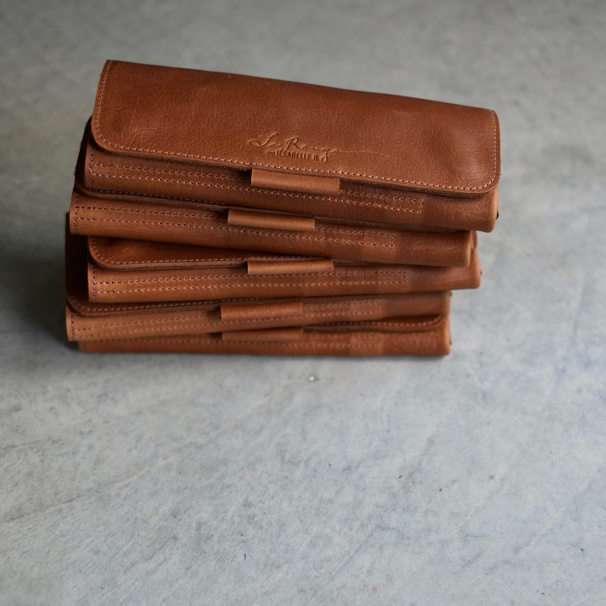 Brown leather needle cases stacked — compact and lightweight for knitters on the go / Étuis en cuir brun empilés — format compact et léger pour tricoteuses en déplacement