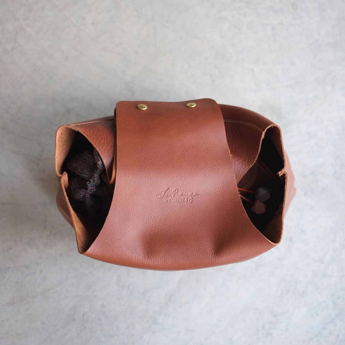 Signature embossed on brown leather yarn pouch in simplicity and elegance / Signature embossée de l'écriture de ma grand-mère sur chaque sac de tricot en cuir faite avec élégance et grâce