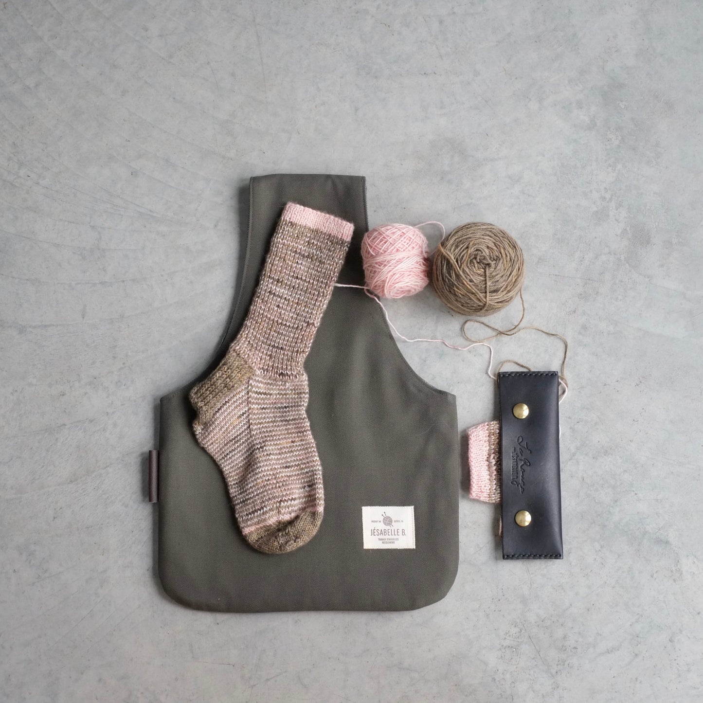 Top view of medium khaki canvas knitting bag with knitted sock to show size / Vue de haut du sac à tricot en canevas vert kaki avec chaussette pour illustrer le format