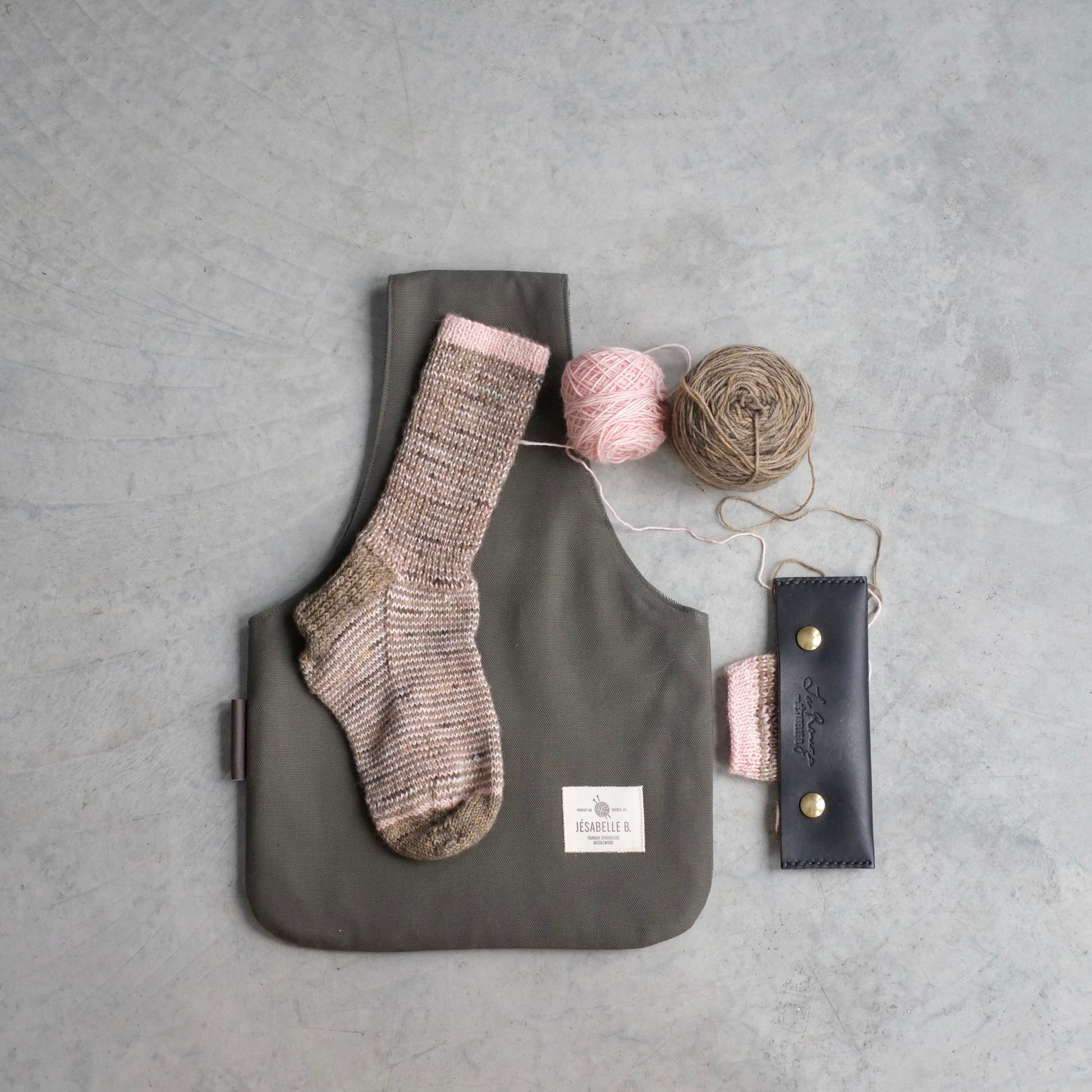 Top view of medium khaki canvas knitting bag with knitted sock to show size / Vue de haut du sac à tricot en canevas vert kaki avec chaussette pour illustrer le format