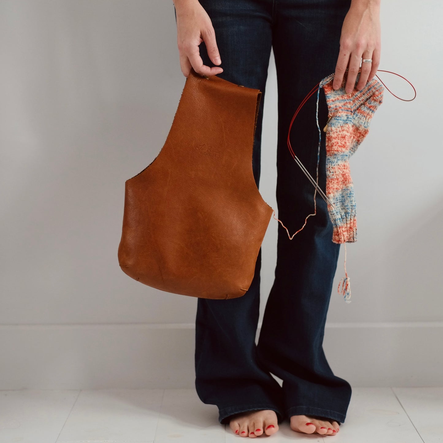 Leather project bag front vieux with a knitted sock for size / Pochette de tricot vu de face avec une chaussette pour illustrer le format