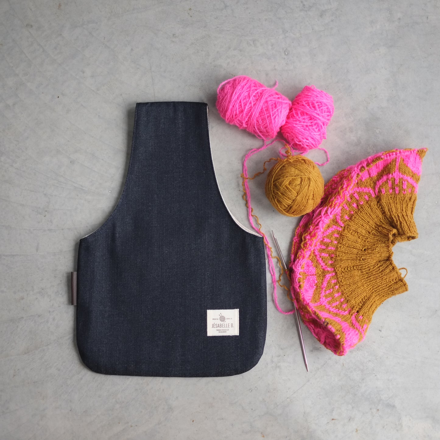 Top view of medium dark navy denim knitting bag with sweater project beside / Vue de haut du sac de tricot moyen en denim bleu foncé avec début de chandail à côté