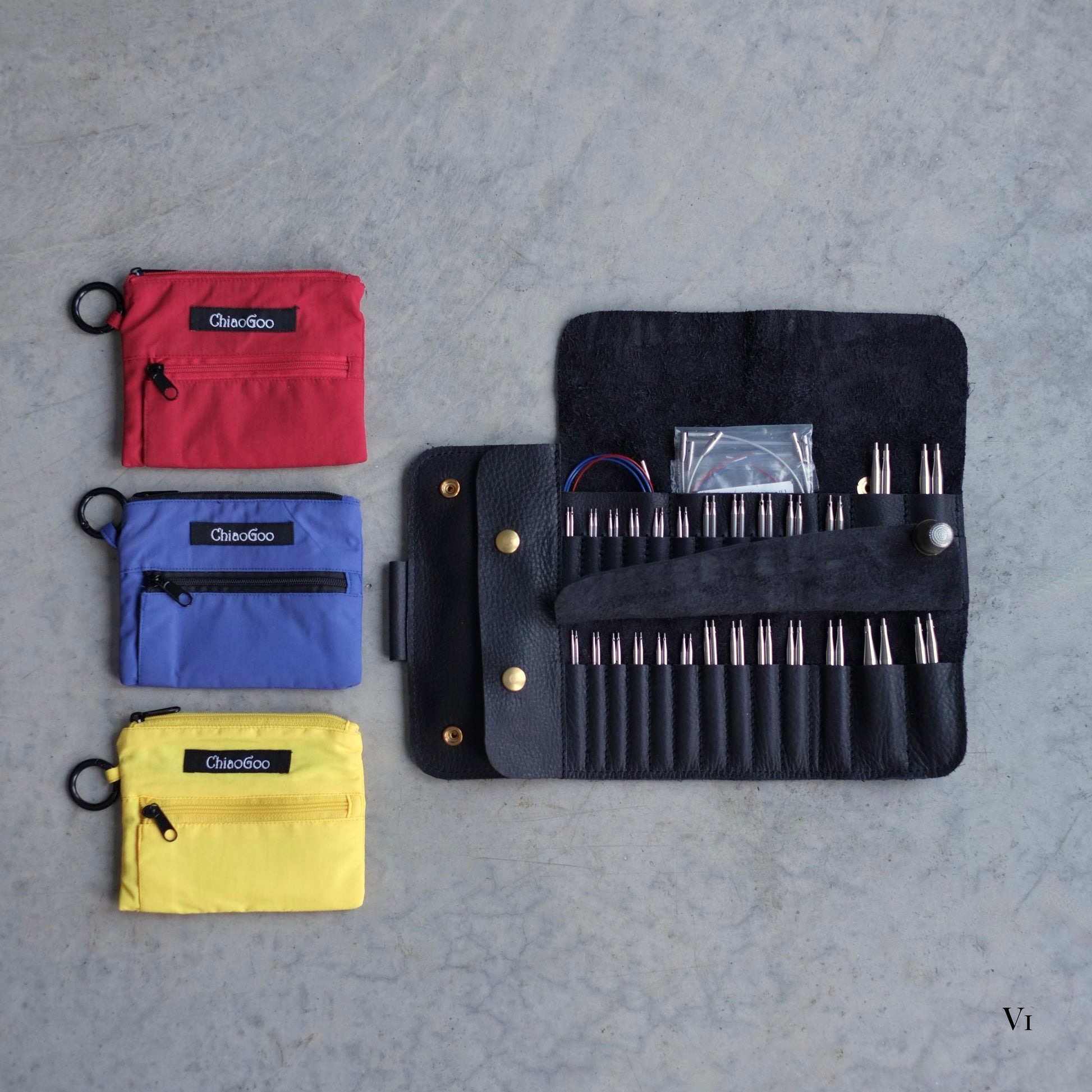 Top new of the open black leather case and the needle kits that fit in it / Vue de haut de l'étui en cuir noir qui contient les trois ensembles tout en un