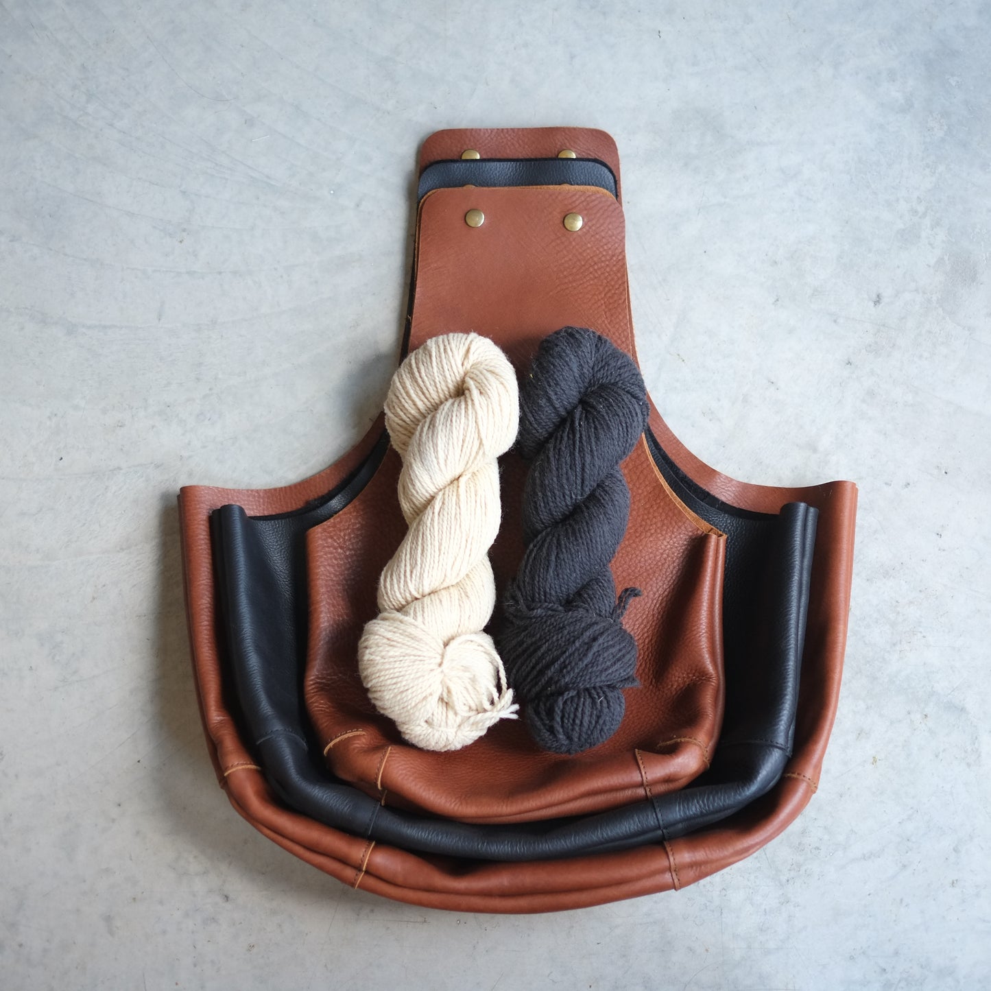 Three sizes of leather knitting bags on one another to show the difference / Trois sac de cuir empilés un sur l'autre pour montrer la différence de grandeur.