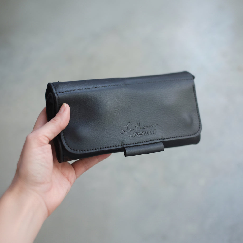 Étui à crochets en cuir noir fermé tenu dans une main — format compact et portable, idéal cadeau crocheteur-teuse, fait main au Canada, Jésabelle B. | Black leather crochet case closed held in hand — compact and portable, perfect gift for crocheters, handmade in Canada, Jésabelle B.

