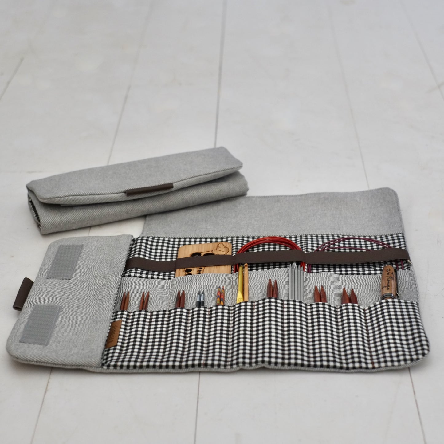 Étui d'aiguilles denim gris ouvert et fermé côte à côte — aiguilles circulaires interchangeables et câbles parfaitement rangés, Jésabelle B. | Grey denim needle case open and closed side by side — interchangeable circular knitting needles and cables neatly organized, Jésabelle B.